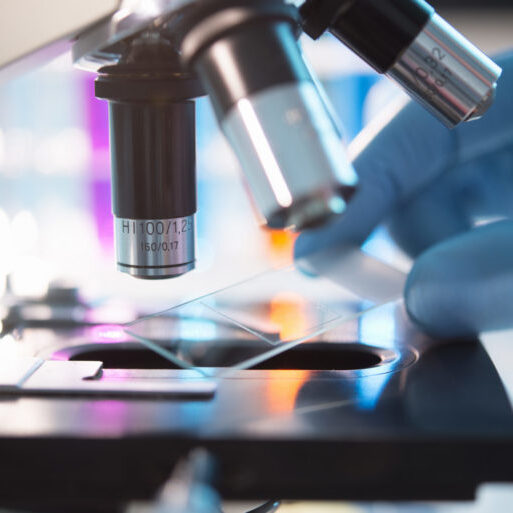 A scientist placing a slide under a microscope